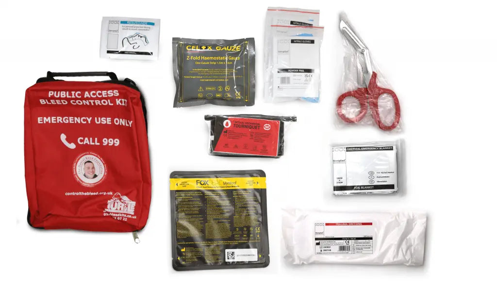 Collection of emergency medical supplies including a red bag labeled 'Public Access Bleed Control Kit' on a white background.