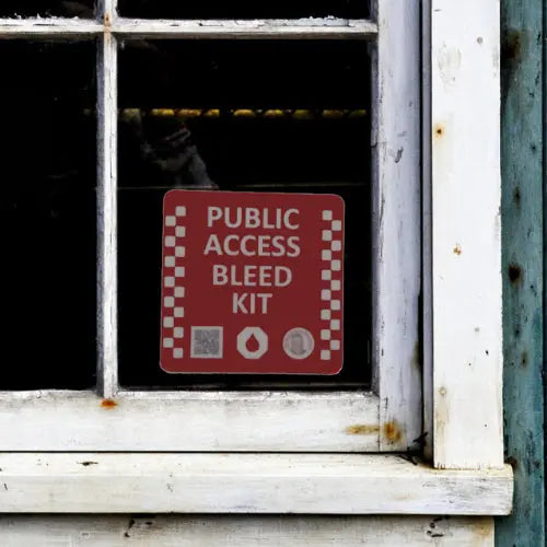 Red 'Public Access Bleed Kit' sign on a window